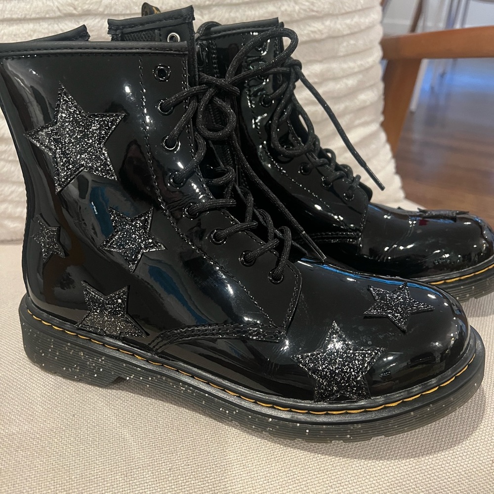 Dr. Marten black patent glitter star lace up boots.